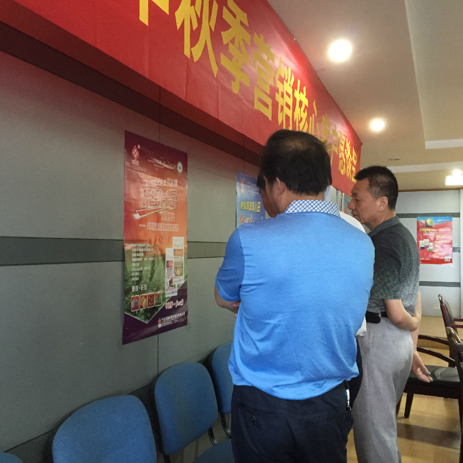 會議前，復(fù)合肥經(jīng)銷商正在觀看廳里掛的宣傳海報